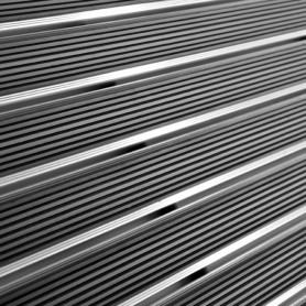 Tapis d’entrée sur structure aluminium, sections rectilignes en acier ou aluminium, motif à bandes parallèles et petites fentes