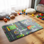 Tapis de jeu réversible City 67×100 cm posé sur parquet, with route et immeubles colorés, jouets en bois autour et coussins.