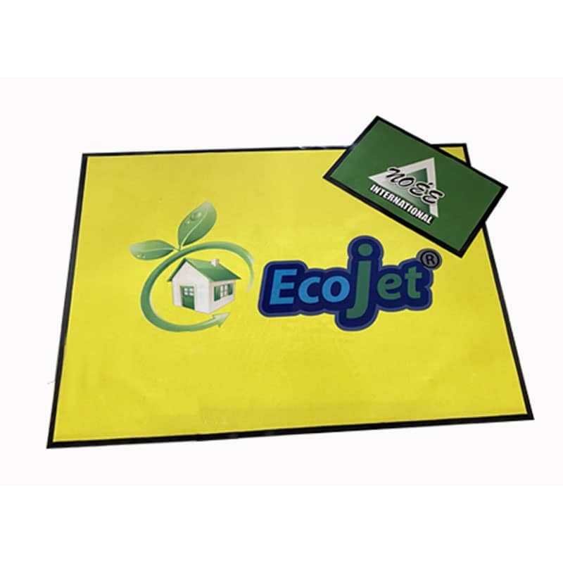 Tapis d’entrée jaune vif avec logo “EcoJet” et étiquette verte “Aozis International” posé dessus. Tapis d’entrée jaune vif avec logo “EcoJet” et étiquette verte “Aozis International” posé dessus.